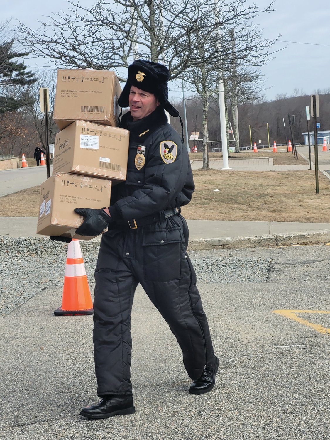 HEAVY LOAD: Johnston Police Chief Joseph P. Razza carries boxes full of take-home Covid testing kits during a drive-through Point of Distribution (POD).